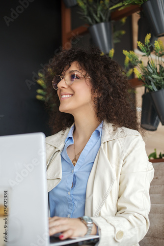 Young beautiful woman with laptop , smartphone and coffee in a Restaurant 