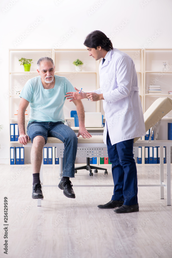 Fototapeta premium Old man visiting young male doctor 