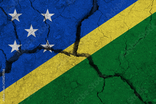 Solomon Islands flag on the cracked earth