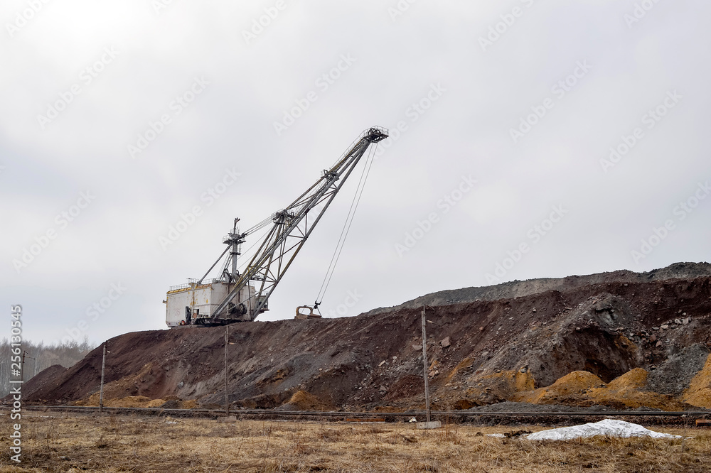 Large walking excavator in anticipation of rolling stock transporting overburden for storage in dumps. Large walking excavator in anticipation of rolling stock transporting overburden for storage in dumps.
