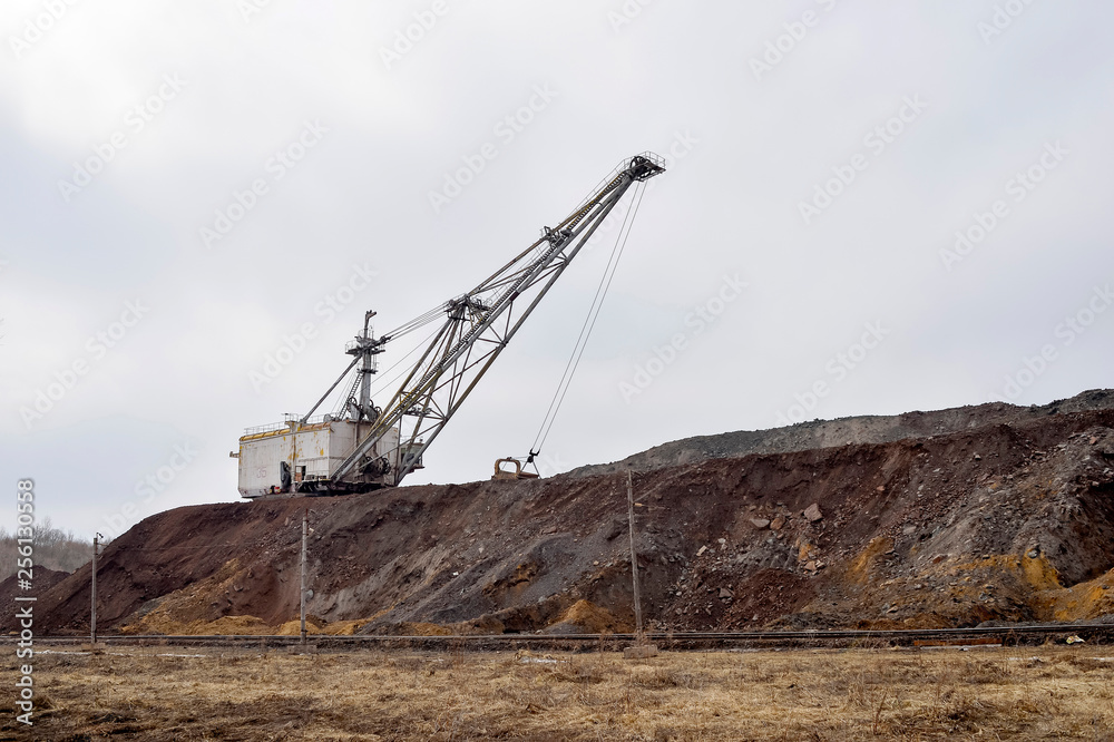 Large walking excavator in anticipation of rolling stock transporting overburden for storage in dumps. Large walking excavator in anticipation of rolling stock transporting overburden for storage in dumps.
