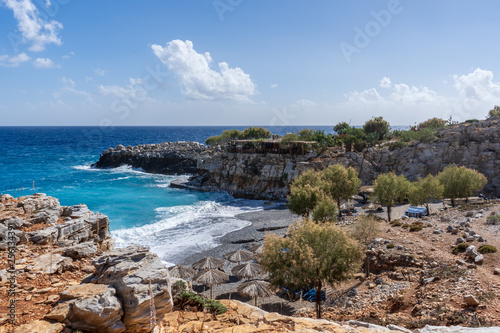 View over bay of Marmara Beach with parasolas on the beach and turquoise waters in front of a tavern near the Aradena gorge on Crete island, Greece photo