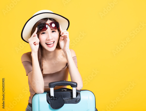 happy tourist woman in summer hat holding sunglasses and suitcase