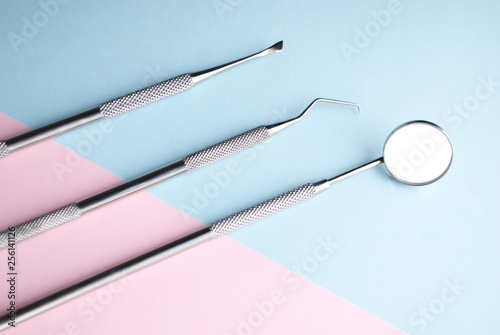 Dental instrments on pink and blue. Dental care concept. Dental treatment. photo