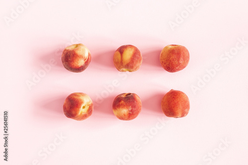Peaches on pastel pink background. Flat lay, top view