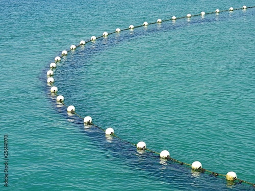 Submerged shark net with buoys in water background photo