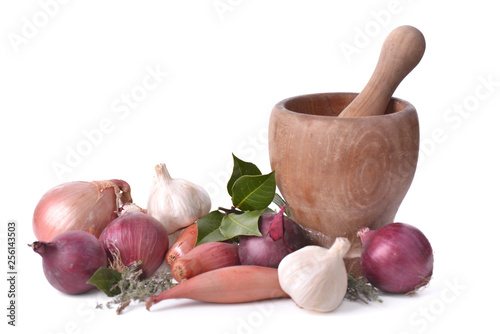 onions, garlics and shallots with a wooden pestle on white background