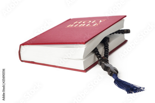 Bible on a white background. Sacred book and wooden rosary. photo