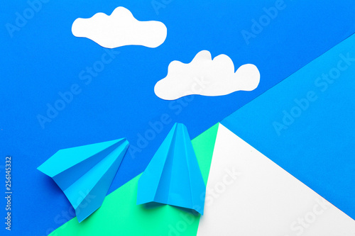 Paper plane  on a blue background with clouds