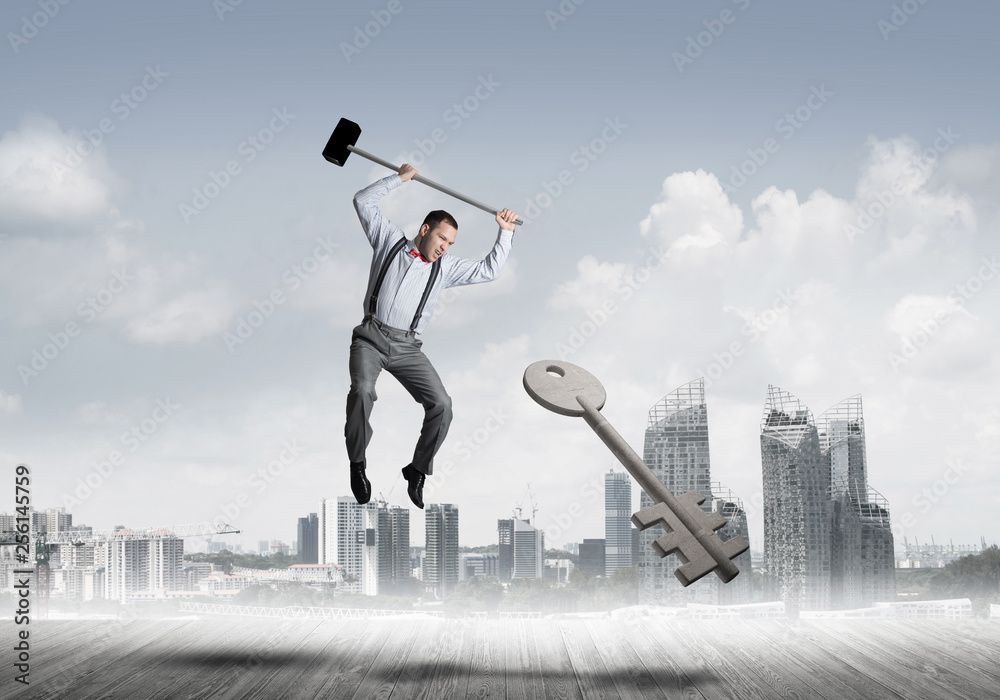 Breaking through access concept with man in anger crashing concrete key Breaking through access concept with man in anger crashing concrete key