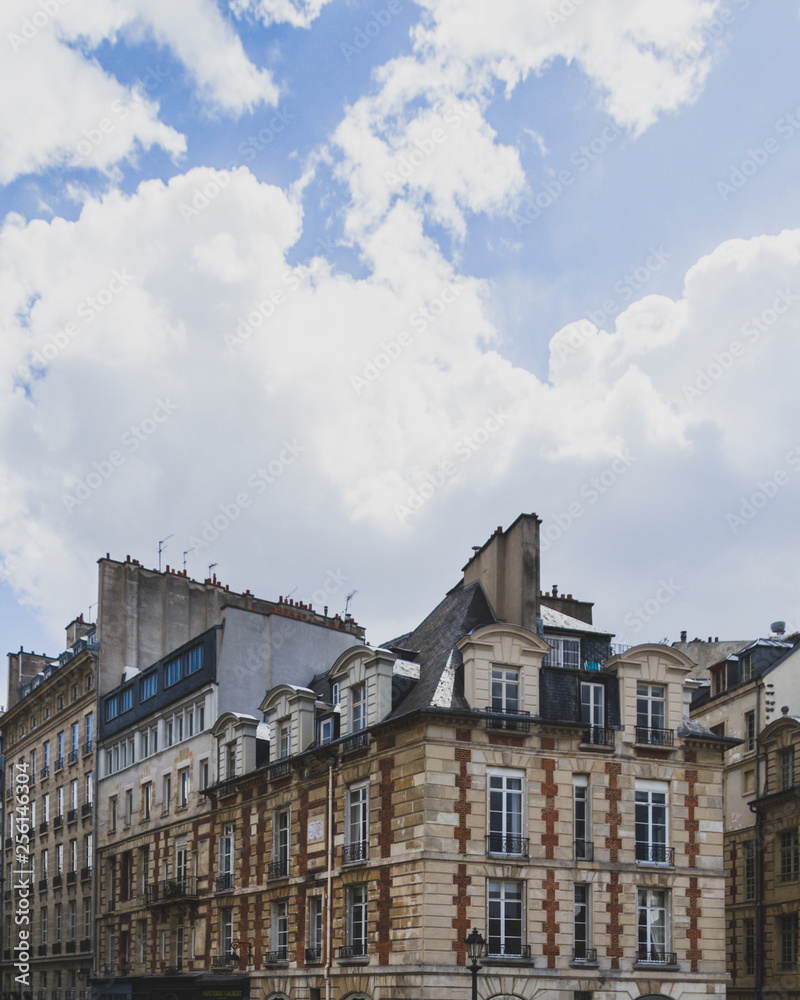 Parisian buildings under clouds and sky in Paris, France