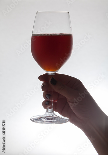 Hand holding  glass goblet with wine