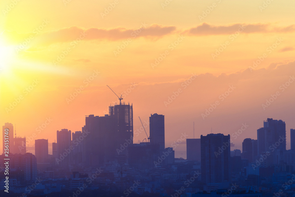 Sunset view of city skyline with bright emotional and powerful energy from light.  First sunlight at dusk.