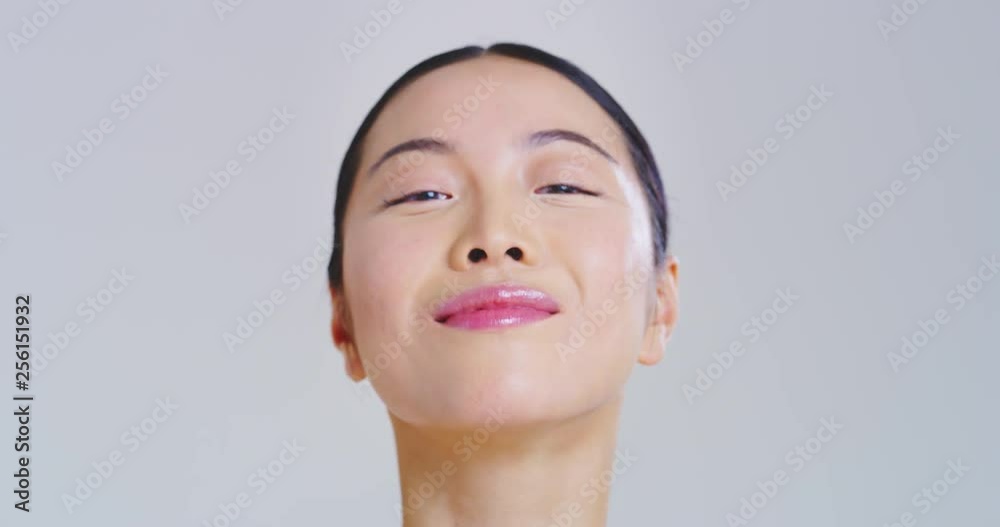 Slow motion of asian woman with beautiful face and perfect skin just cleaned from impurities ready for day or night cream is smiling in camera. Slow motion of asian woman with beautiful face and perfect skin just cleaned from impurities ready for day or night cream is smiling in camera.