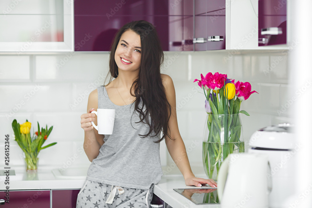 Young beautiful woman in the early morning having coffee on the kitchen. Fresh morning. Bracing drink. Fees for work. Awake lady. Young beautiful woman in the early morning having coffee on the kitchen. Fresh morning. Bracing drink. Fees for work. Awake lady.