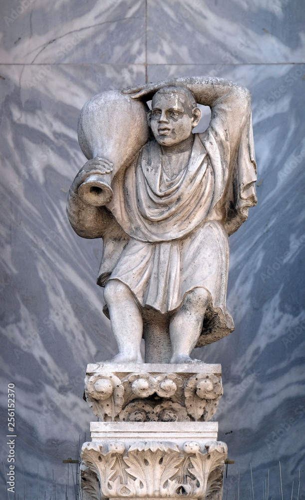 Obraz premium Sculpture of a man carrying a wine jug at St. Mark's Basilica, detail of the facade of the Saint Mark's Basilica, St. Mark's Square, Venice, Italy, UNESCO World Heritage Sites