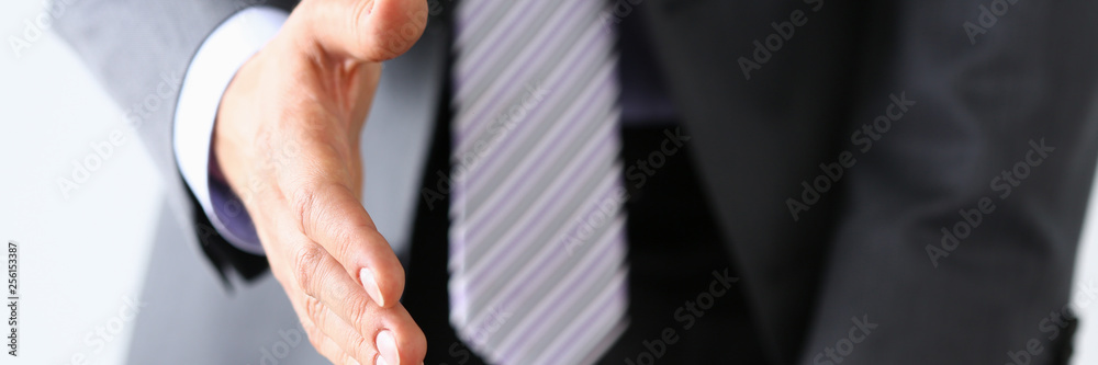 Fototapeta premium Man in suit and tie give hand as hello in office closeup