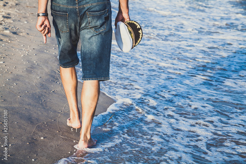 Man walks on the sea beach photo