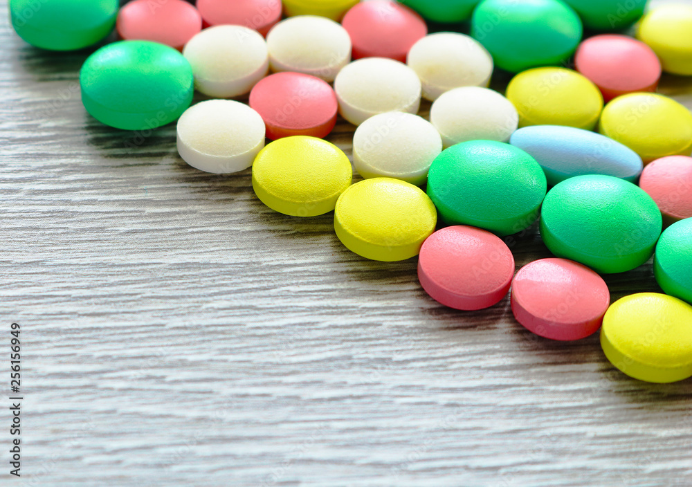 A lot of multi-colored tablets of different shapes. Pills are used in medicine to heal people. A lot of multi-colored tablets of different shapes. Pills are used in medicine to heal people.