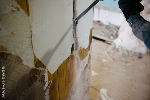 A worker drills a wall using a perforator. Repair in the apartment