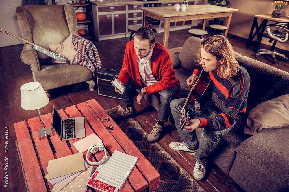 Fototapeta premium Modern talented musicians using gadgets while composing new song
