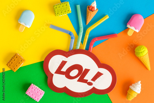 Photography Lol text in speech bubble with drinking straws, ice cream and biscuits against multicolored background abstract