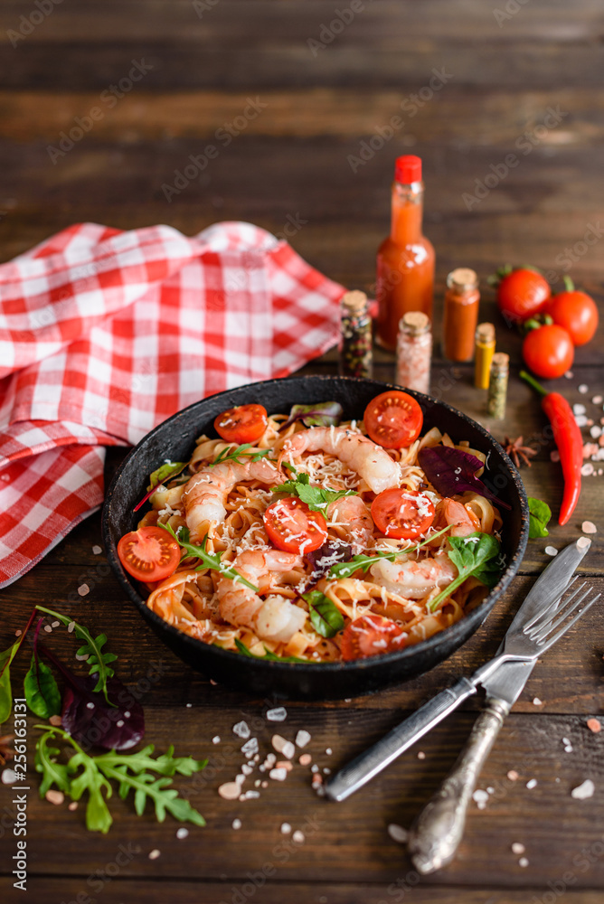 Tasty pasta with shrimp and tomato on a frying pan Tasty pasta with shrimp and tomato on a frying pan