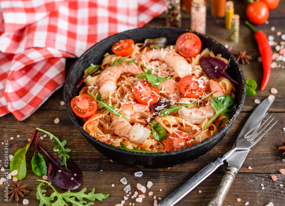 Tasty pasta with shrimp and tomato on a frying pan Tasty pasta with shrimp and tomato on a frying pan