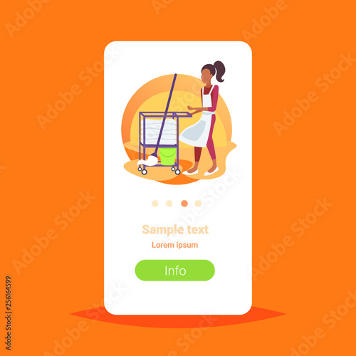 african american chambermaid with maid cart cleaning supplies hotel room service concept female housekeeping worker full length copy space