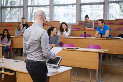 Lecturer and multinational group of students in an auditorium