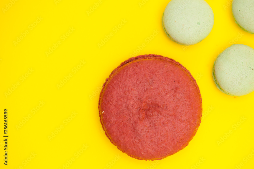 Big cherry macaroon flavour macaroon next to little green tea flavour macaroons Big cherry macaroon flavour macaroon next to little green tea flavour macaroons