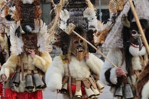 Zemen, Bulgaria - March 16, 2019: Masquerade festival Surva in Zemen, Bulgaria. People with mask called Kukeri dance and perform to scare the evil spirits. photo