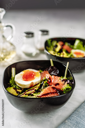 Two bowls with salad, egg and salmon for breakfast