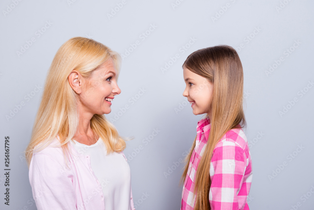 Profile side view portrait of two nice cute charming attractive lovely adorable sweet tender cheerful people wearing casual isolated over gray pastel background Profile side view portrait of two nice cute charming attractive lovely adorable sweet tender cheerful people wearing casual isolated over gray pastel background