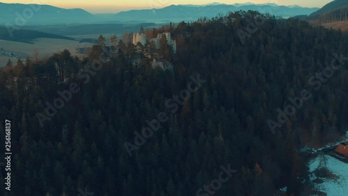 Aerial drone footage going towards forest of pine trees that surrounds castle Blatnica in the Turiec region of Slovakia photo