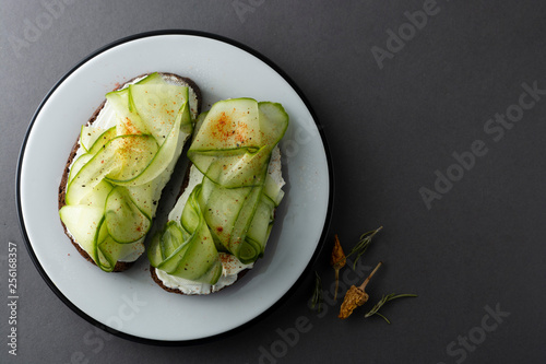 Cucumber sandwich. Healthy snack. Sandwich with cream cheese, cucumber, served on a plate. Symbolic image. Concept for a tasty and healthy meal. Copy space.