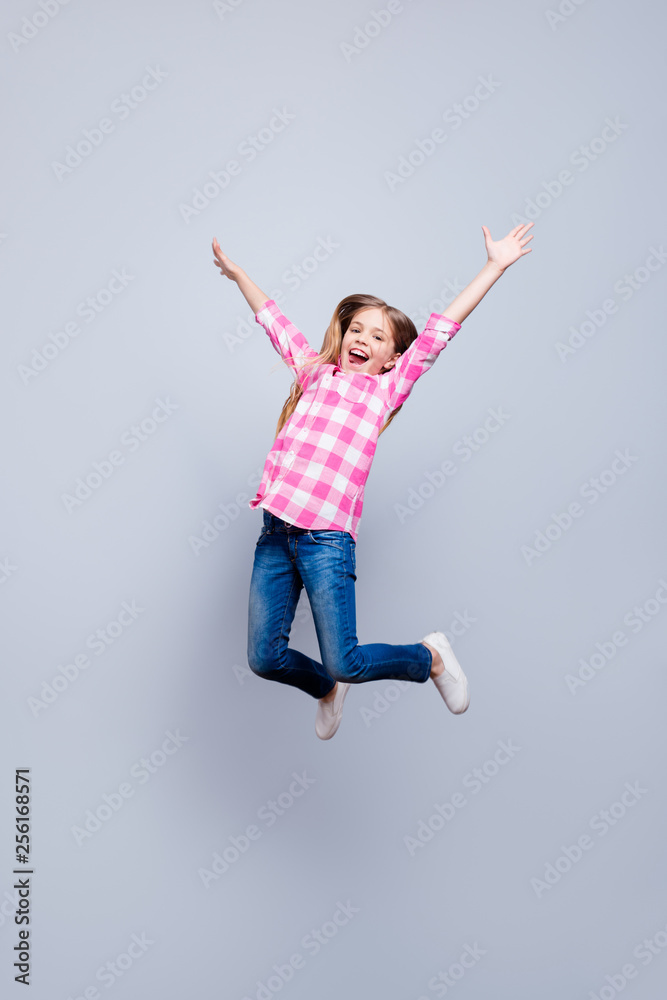 Full length body size vertical photo blond haired she her little cheerleader laugh laughter jump high achievement wear casual jeans pink plaid checkered shirt outfit clothes isolated grey background
