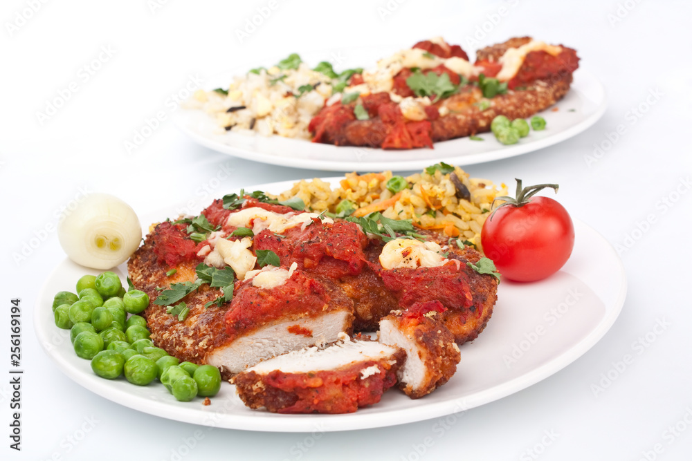two plates of chicken parmesan on white background