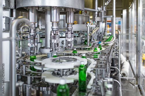 Bottling plant - Water bottling line for processing and bottling pure spring water into green glass bottles. Selective focus. photo