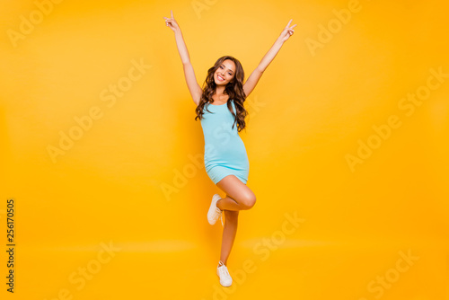 Full length body size photo amazing beautiful her she lady hands arms raised show v-sign slim skinny ideal shape fit  wearing blue teal green everyday short dress clothes isolated yellow background