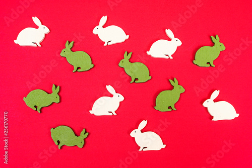 some wooden colored Easter bunnies on a red surface