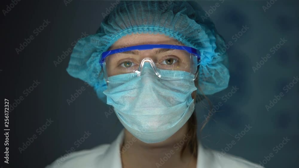 Scientist in protective uniform looking to camera, tired doctor after surgery Scientist in protective uniform looking to camera, tired doctor after surgery
