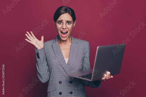 Portrait of nice attractive classy crazy nervous lady financier director ceo boss chief in gray checkered blazer holding in hands laptop resent isolated over maroon burgundy marsala pastel background