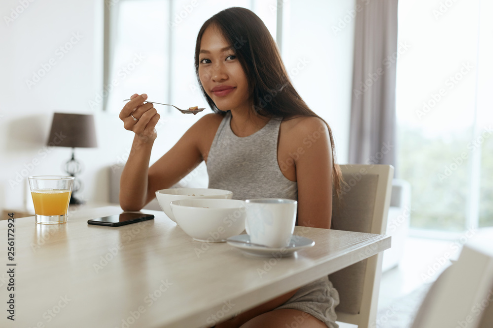 Woman eating healthy breakfast at home in morning at table Woman eating healthy breakfast at home in morning at table