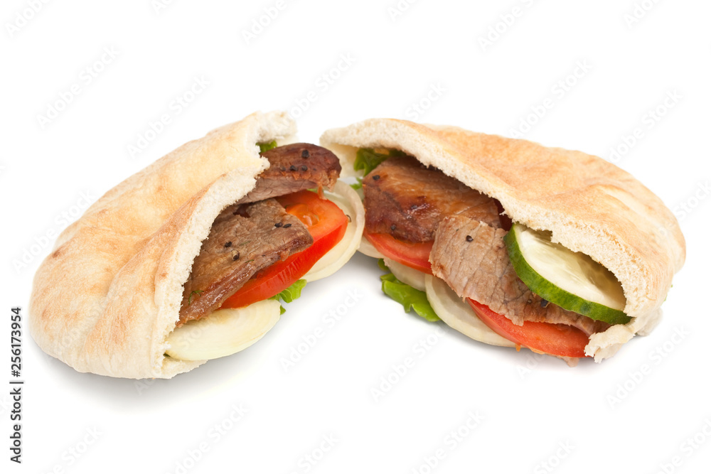 Two halves of pita bread sandwich with meat and vegetables