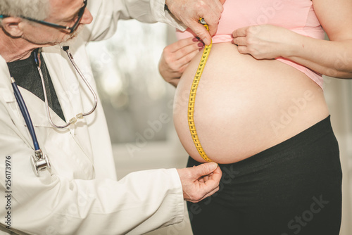 Doctor measuring belly size of pregnant woman