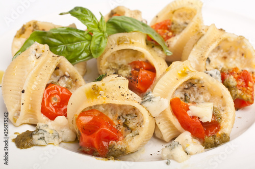 pasta shell stuffed with various cheese, pesto sauce and cherry tomatoes