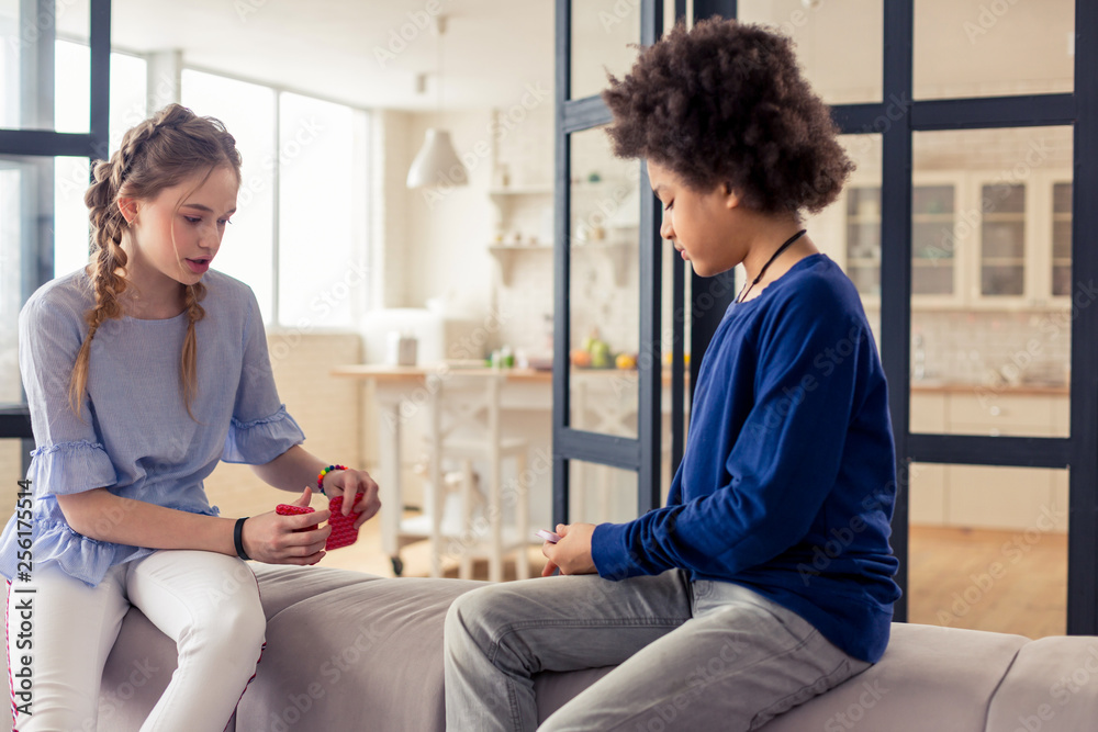 Concentrated curly-haired teenager looking at his cards Concentrated curly-haired teenager looking at his cards