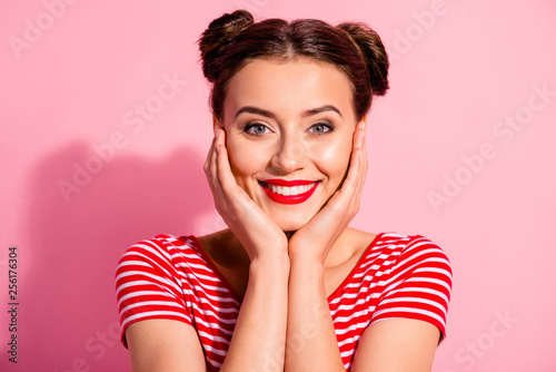 Close up photo beautiful she her lady pretty two buns bright pomade lipstick touch hold arms hands cheeks cheekbones show white teeth wear casual striped red white t-shirt isolated pink background