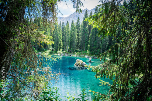 lago di carezza or karersee, a beautiful lake in the dolomites mountains surrounded by conifers, south tyrol, italy